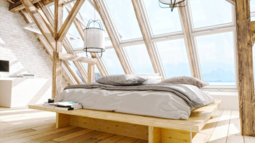 Interior of a Scandinavian style attic bedroom with beautiful sea and mountain view.